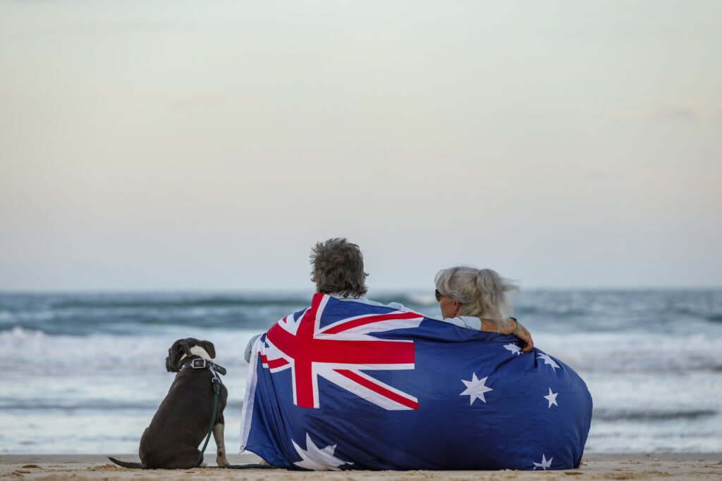 beautiful shot of a couple on the beach with blue english stafford dog